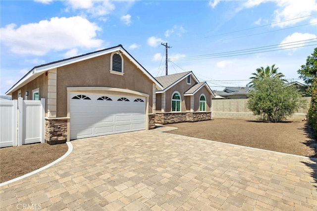 11128 Stamy Rd, Whittier, CA 90604 - ranch-style home with stone siding, decorative driveway, stucco siding, and an attached garage