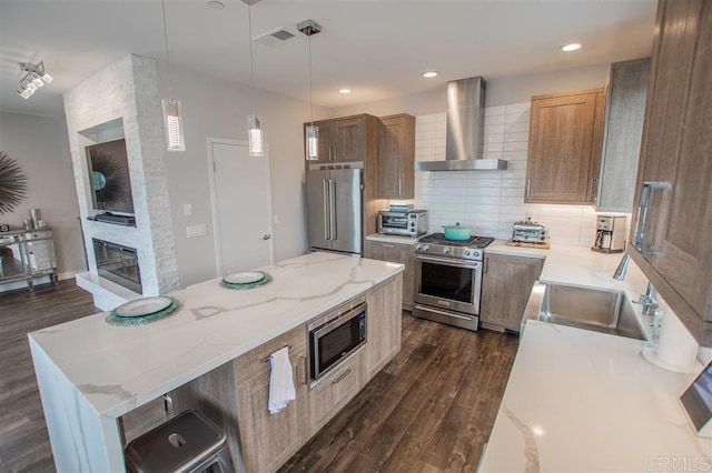 7570 Gibraltar St Unit 101, Carlsbad, CA 92009 - kitchen featuring premium appliances, wall chimney exhaust hood, dark wood-type flooring, decorative backsplash, and recessed lighting