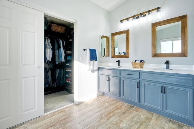 5232 Palmera Dr, Oceanside, CA 92056 - full bathroom with wood finished floors, double vanity, and a walk in closet
