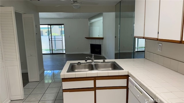 44460 15th St E Unit 13, Lancaster, CA 93535 - kitchen featuring tile countertops, white dishwasher, white cabinetry, open floor plan, and healthy amount of natural light