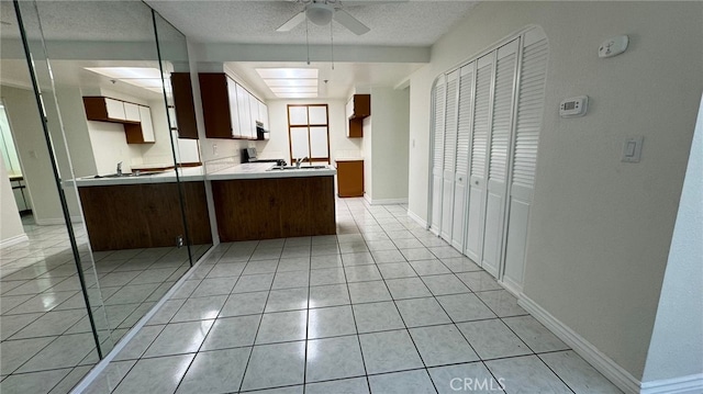 44460 15th St E Unit 13, Lancaster, CA 93535 - kitchen featuring ceiling fan, light tile patterned floors, a textured ceiling, a peninsula, and light countertops