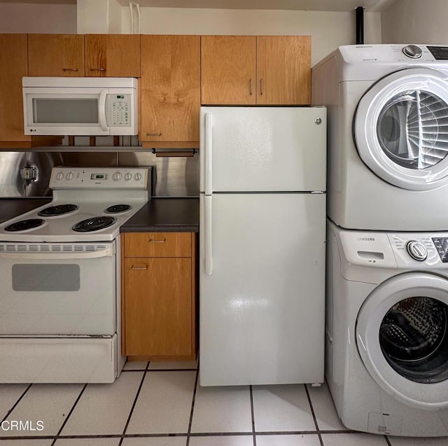 980 N Hoover St, Los Angeles, CA 90029 - kitchen with white appliances, stacked washer and clothes dryer, light tile patterned flooring, dark countertops, and brown cabinetry