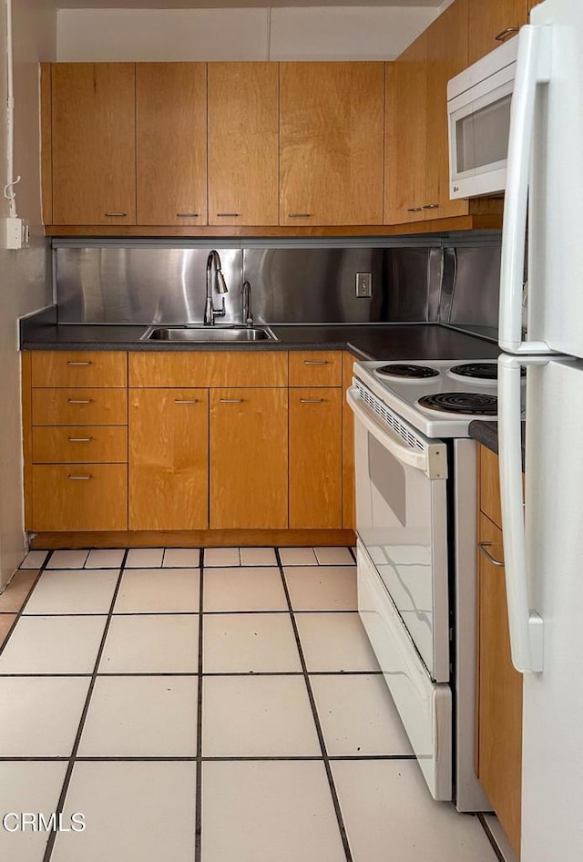 980 N Hoover St, Los Angeles, CA 90029 - kitchen featuring white appliances, brown cabinets, dark countertops, and light tile patterned floors