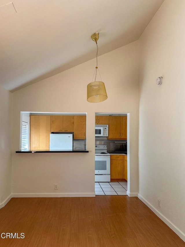 980 N Hoover St, Los Angeles, CA 90029 - kitchen with white appliances, brown cabinets, light wood-style flooring, dark countertops, and hanging light fixtures