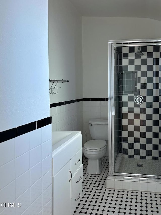 980 N Hoover St, Los Angeles, CA 90029 - full bathroom with tile walls, a shower stall, vanity, tile patterned flooring, and a wainscoted wall