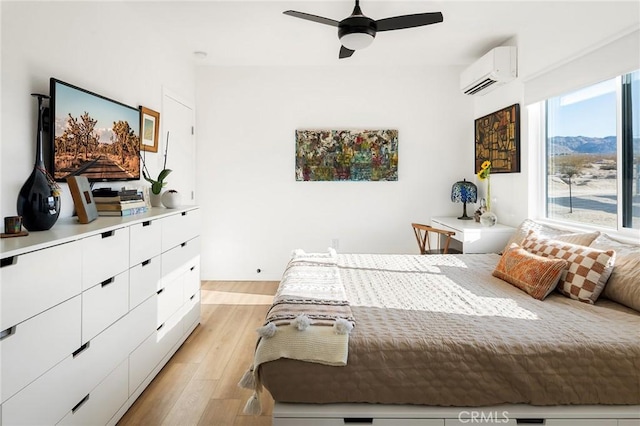 67712 Whitmore Rd Unit 29, Palms, CA 92277 - bedroom featuring a wall mounted air conditioner, light wood-style floors, and ceiling fan