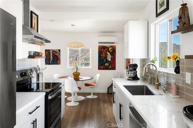 67712 Whitmore Rd Unit 29, Palms, CA 92277 - kitchen with range with electric stovetop, wall chimney range hood, a wall mounted AC, freestanding refrigerator, and dishwasher