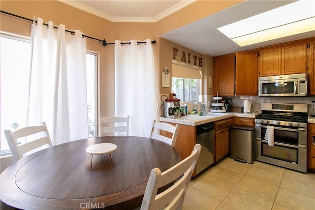 13421 Hubbard St Unit 119, Sylmar, CA 91342 - kitchen featuring stainless steel appliances, tile counters, brown cabinets, light tile patterned floors, and tasteful backsplash