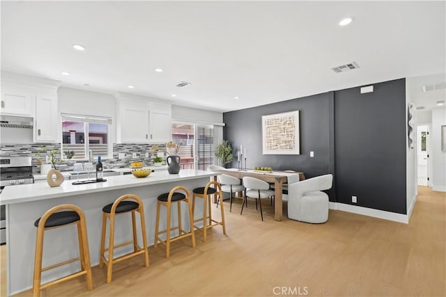 20832 Halldale Ave, Torrance, CA 90501 - kitchen featuring stainless steel gas range, under cabinet range hood, tasteful backsplash, white cabinets, and recessed lighting