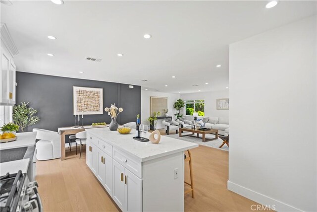 20832 Halldale Ave, Torrance, CA 90501 - kitchen with white cabinetry, recessed lighting, a kitchen bar, and light wood-style floors