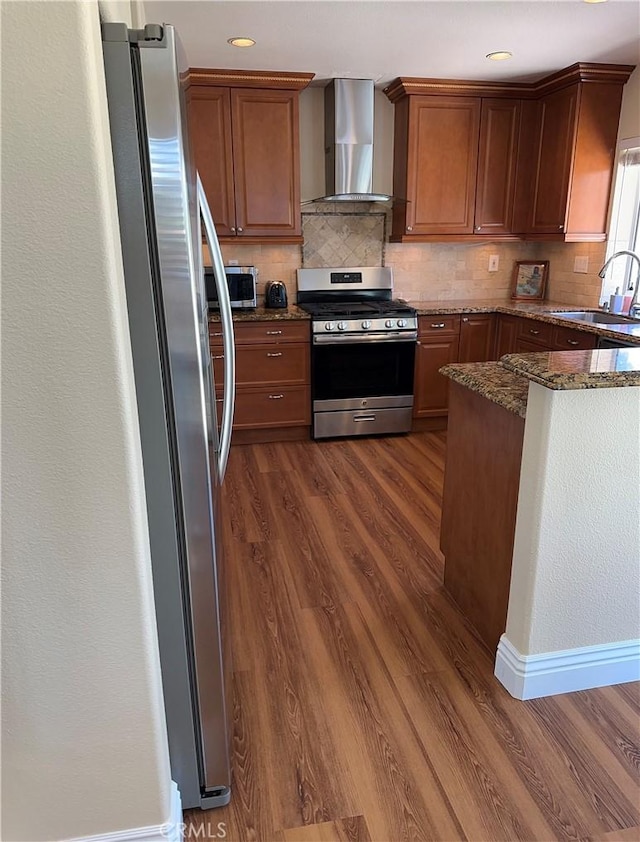 2690 Peralta Ct, Tustin, CA 92782 - kitchen with wall chimney range hood, stainless steel appliances, dark wood-style flooring, tasteful backsplash, and recessed lighting