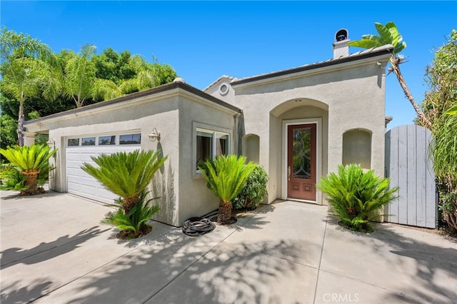 210 N Stage Coach Ln, Fallbrook, CA 92028 - view of front facade with a garage, driveway, stucco siding, and a chimney