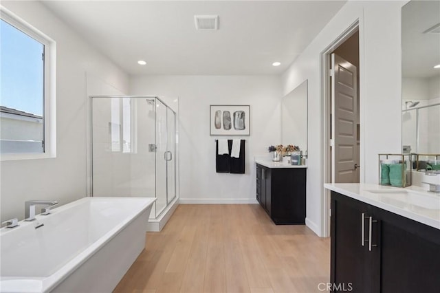 38840 Malva Rosa Dr, Palmdale, CA 93551 - bathroom with vanity, a shower stall, a freestanding bath, wood finished floors, and recessed lighting