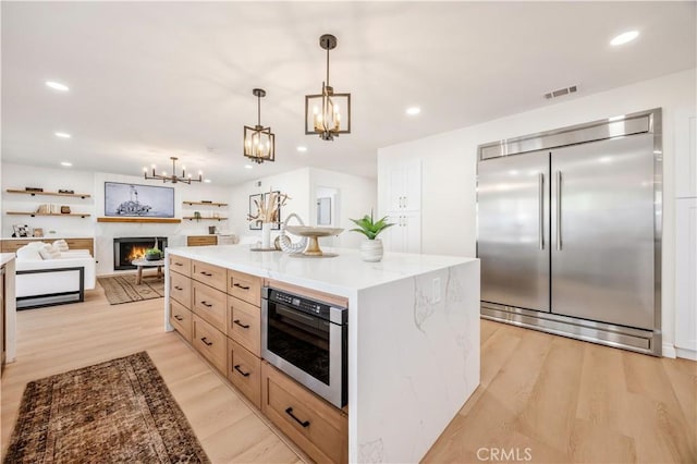 26592 Tampico Pl, Mission Viejo, CA 92691 - kitchen featuring stainless steel built in refrigerator, a chandelier, light wood finished floors, pendant lighting, and light stone countertops