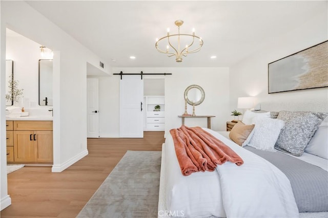 26592 Tampico Pl, Mission Viejo, CA 92691 - bedroom with a barn door, light wood-type flooring, a chandelier, recessed lighting, and ensuite bath
