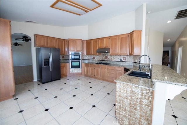 13436 Havasu Rd, Apple Valley, CA 92308 - kitchen featuring black appliances, under cabinet range hood, a peninsula, backsplash, and light stone countertops