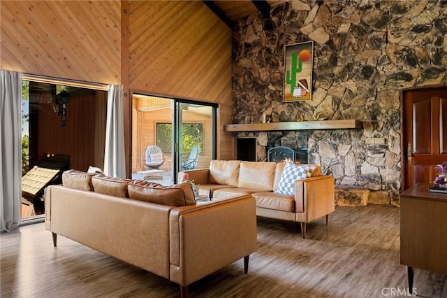 161 Pine Ridge Rd, Crestline, CA 92325 - living room with high vaulted ceiling, wood finished floors, a stone fireplace, wooden walls, and a wood ceiling with exposed beams