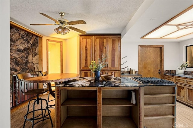 161 Pine Ridge Rd, Crestline, CA 92325 - kitchen featuring open shelves, brown cabinetry, light wood-type flooring, a textured ceiling, and a ceiling fan