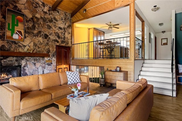 161 Pine Ridge Rd, Crestline, CA 92325 - living area with ceiling fan, wood finished floors, a wood ceiling with exposed beams, a stone fireplace, and wood walls