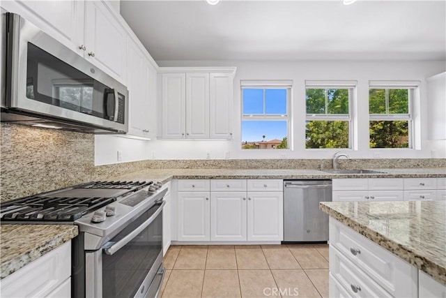 20916 Jade Dr, Walnut, CA 91789 - kitchen with stainless steel appliances, white cabinets, light tile patterned flooring, light stone countertops, and tasteful backsplash