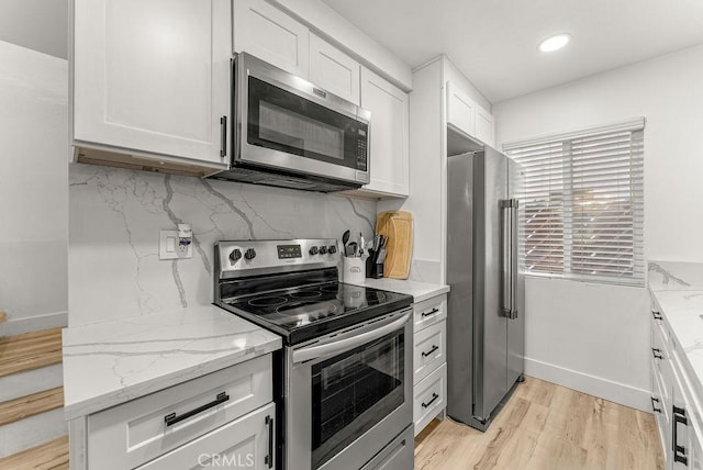 1745 Neil Armstrong Ave Unit 104, Montebello, CA 90640 - kitchen with stainless steel appliances, light wood-style floors, white cabinetry, backsplash, and light stone countertops