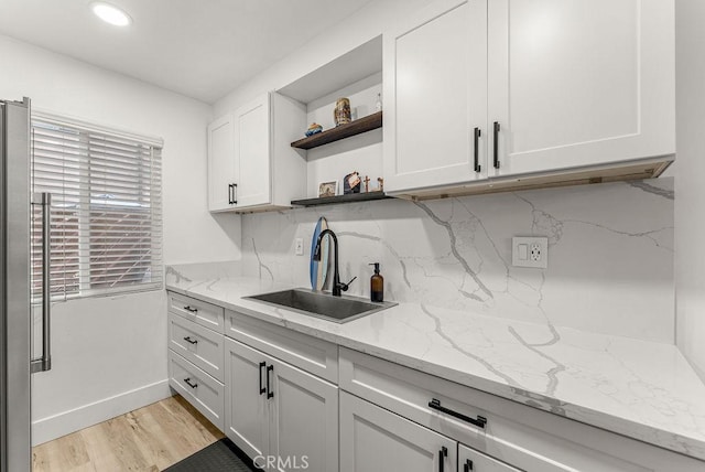 1745 Neil Armstrong Ave Unit 104, Montebello, CA 90640 - kitchen featuring open shelves, high quality fridge, white cabinets, light wood-type flooring, and light stone counters