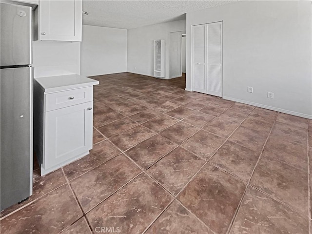 8800 Cedros Ave Unit 209, Panorama City, CA 91402 - unfurnished living room featuring a textured ceiling and dark tile patterned floors