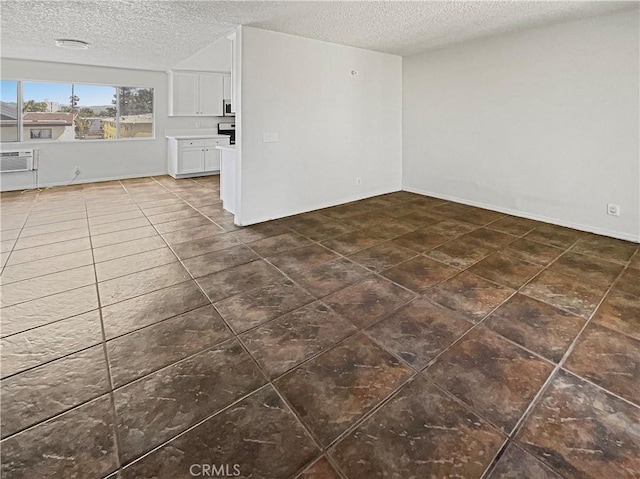 8800 Cedros Ave Unit 209, Panorama City, CA 91402 - unfurnished living room featuring a textured ceiling, dark tile patterned floors, and a wall mounted AC