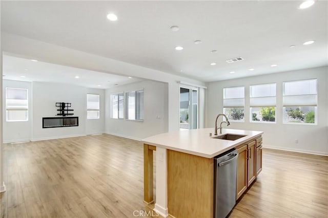32210 Hillstone St, Temecula, CA 92591 - kitchen featuring stainless steel dishwasher, light wood-style floors, a center island with sink, light countertops, and recessed lighting
