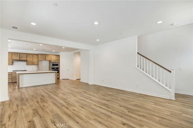 32210 Hillstone St, Temecula, CA 92591 - unfurnished living room featuring light wood-style floors, recessed lighting, and stairs