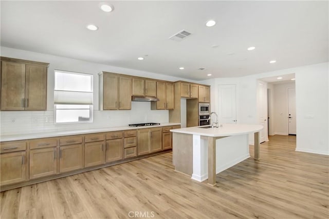 32210 Hillstone St, Temecula, CA 92591 - kitchen featuring gas cooktop, stainless steel microwave, tasteful backsplash, recessed lighting, and light wood finished floors