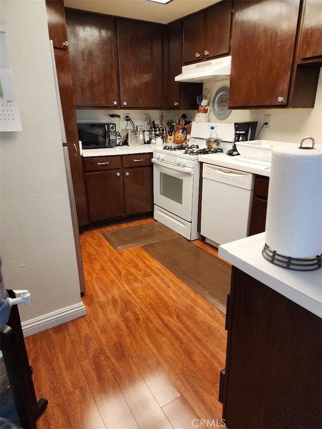 15116 S Raymond Ave Unit 104, Gardena, CA 90247 - kitchen featuring white appliances, light wood-style flooring, light countertops, and under cabinet range hood