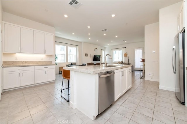 251 Sash, Irvine, CA 92618 - kitchen featuring appliances with stainless steel finishes, light tile patterned flooring, an island with sink, white cabinets, and recessed lighting