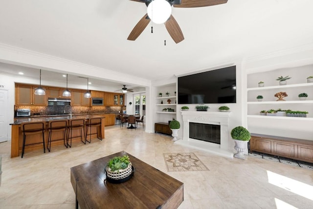 2814 Rambling Vista Rd, Chula Vista, CA 91915 - living area with a ceiling fan, a glass covered fireplace, crown molding, light tile patterned floors, and built in features