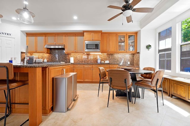 2814 Rambling Vista Rd, Chula Vista, CA 91915 - kitchen with stainless steel appliances, crown molding, backsplash, a kitchen bar, and a ceiling fan