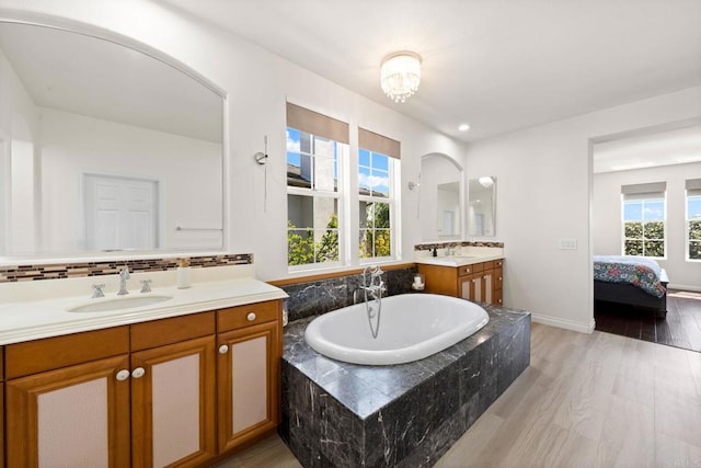 2814 Rambling Vista Rd, Chula Vista, CA 91915 - ensuite bathroom featuring two vanities, a garden tub, wood finished floors, and backsplash