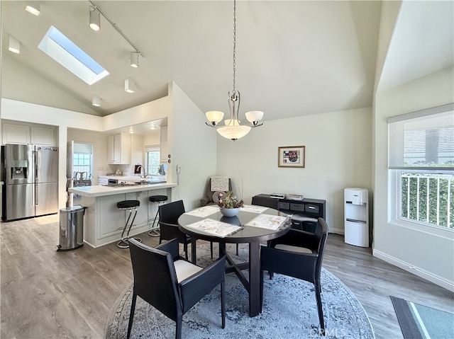 21 Centaurus Unit 3, Irvine, CA 92603 - dining space featuring rail lighting, light wood-type flooring, a skylight, and high vaulted ceiling