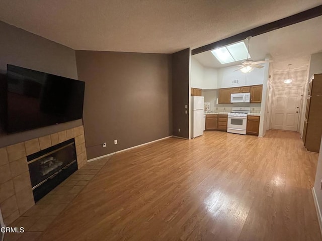 109 B St, Fillmore, CA 93015 - unfurnished living room with light wood finished floors, ceiling fan, a fireplace, and a skylight