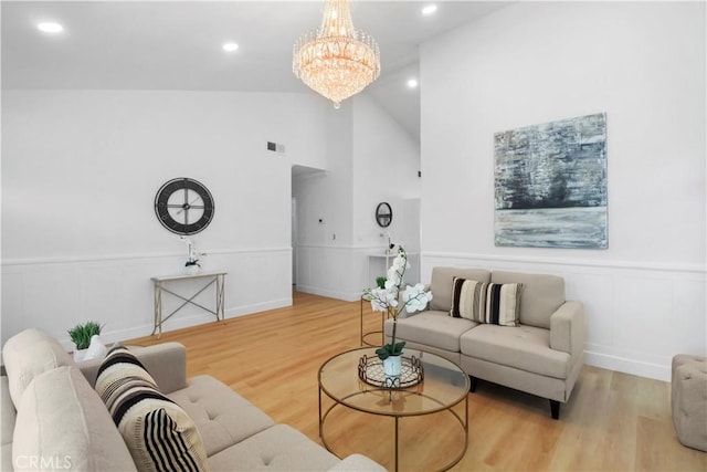 17824 Holmes Ave, Cerritos, CA 90703 - living area featuring a decorative wall, a chandelier, wood finished floors, a wainscoted wall, and vaulted ceiling
