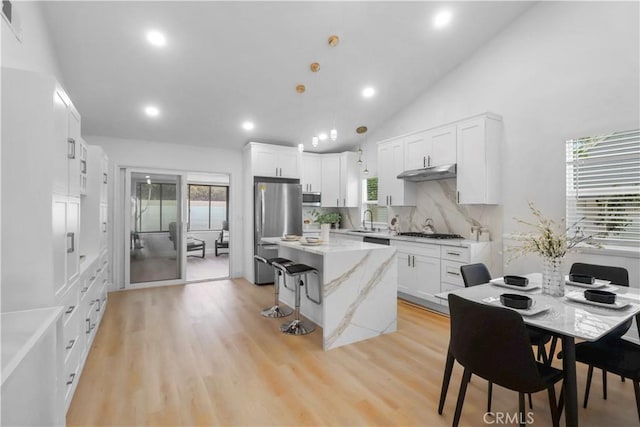 17824 Holmes Ave, Cerritos, CA 90703 - kitchen with appliances with stainless steel finishes, under cabinet range hood, recessed lighting, light stone counters, and tasteful backsplash
