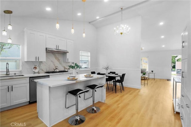 17824 Holmes Ave, Cerritos, CA 90703 - kitchen with stainless steel dishwasher, healthy amount of natural light, a kitchen breakfast bar, decorative backsplash, and recessed lighting