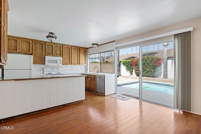1310 Anza Ct, Oxnard, CA 93035 - kitchen featuring white appliances, brown cabinetry, backsplash, dark wood-style flooring, and light countertops