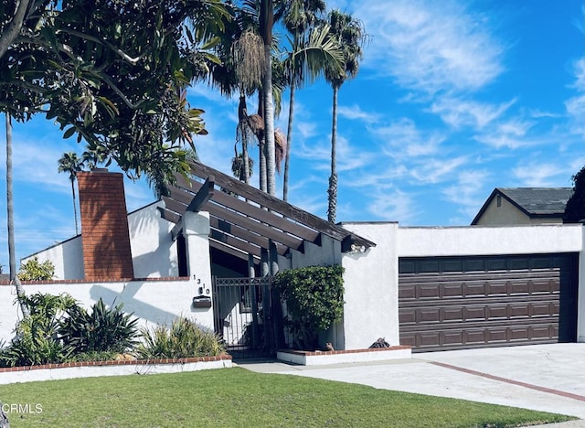 1310 Anza Ct, Oxnard, CA 93035 - view of front of house with a garage, driveway, stucco siding, a chimney, and a gate