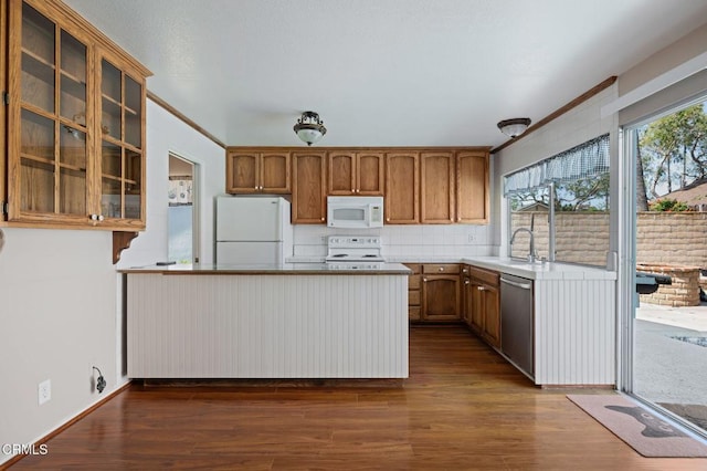 1310 Anza Ct, Oxnard, CA 93035 - kitchen featuring white appliances, a peninsula, glass insert cabinets, dark wood-style floors, and brown cabinetry