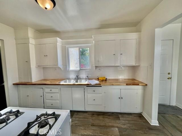430 W 19th St, San Pedro, CA 90731 - kitchen with wooden counters, dark wood-style flooring, gas range gas stove, backsplash, and white cabinets