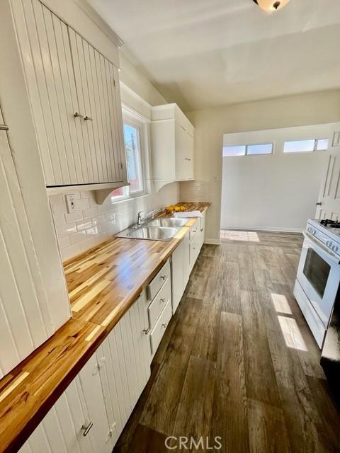 430 W 19th St, San Pedro, CA 90731 - kitchen with white gas range, wooden counters, dark wood-style flooring, decorative backsplash, and white cabinetry