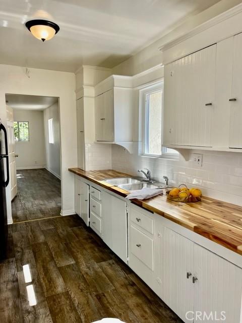 430 W 19th St, San Pedro, CA 90731 - kitchen featuring butcher block countertops, tasteful backsplash, dark wood-type flooring, and white cabinetry
