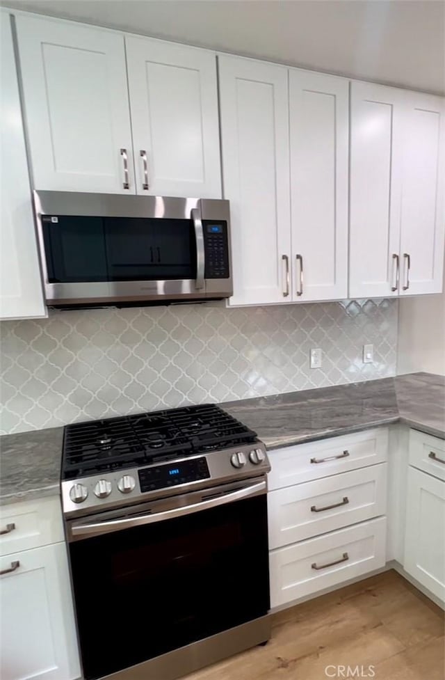 3520 Grand Ave, Huntington Park, CA 90255 - kitchen with appliances with stainless steel finishes, white cabinetry, and backsplash
