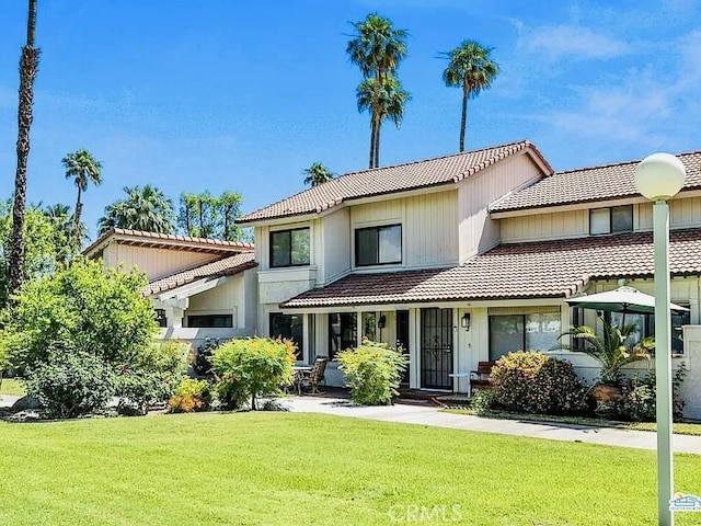 6105 Montecito Dr Unit 5, Palm Springs, CA 92264 - view of front of property featuring a tile roof and a front lawn