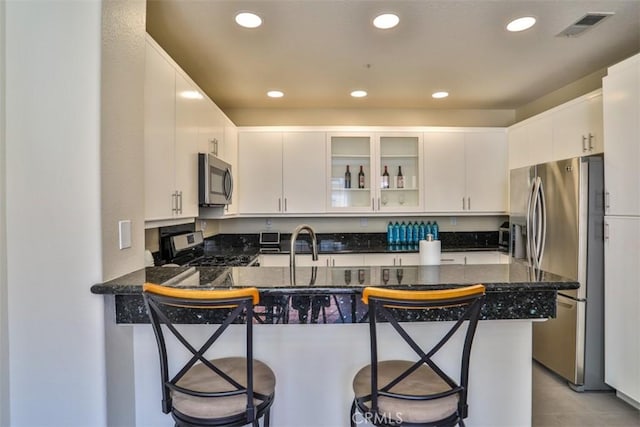 5 Arese Aisle, Irvine, CA 92606 - kitchen with appliances with stainless steel finishes, a peninsula, a breakfast bar, glass insert cabinets, and recessed lighting